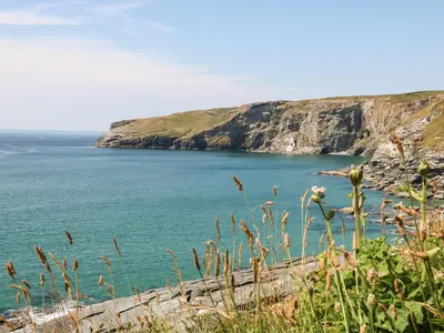 a view of a body of water with a cliff at Beach Hut in Tintagel
