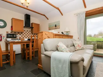 a living room with a couch and a kitchen at Beech Cottage in Truro