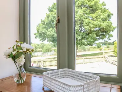 a room with a vase of flowers and a window at Beech Cottage in Truro