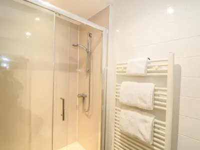 a bathroom with a shower and a glass shower stall at Beech Cottage in Truro