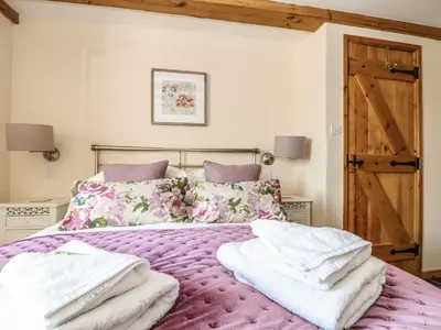 a bedroom with a purple bed with towels on it at Oak Cottage in Truro
