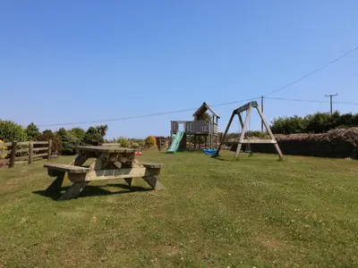 a park with a picnic table and a playground at Oak Cottage in Truro