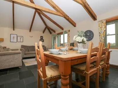 a dining room with a wooden table and chairs at Hawthorn Cottage in Truro