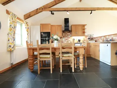 a kitchen with a wooden table and chairs at Hawthorn Cottage in Truro