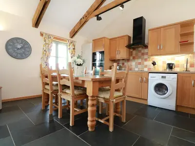 a kitchen with a wooden table and chairs at Hawthorn Cottage in Truro