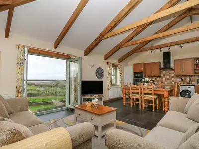 a living room with a couch and a table at Hawthorn Cottage in Truro