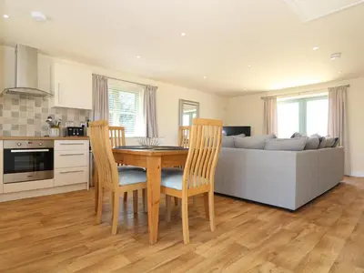a living room with a table and chairs and a couch at Elm Cottage in Truro