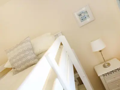a white bunk bed with a pillow and a lamp at Elm Cottage in Truro