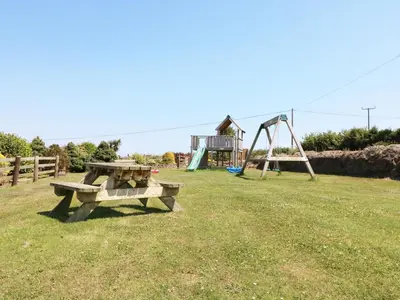 a park with a picnic table and a playground at Elm Cottage in Truro