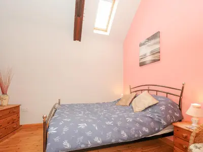 a bedroom with a bed with a blue comforter at Swallows Nest in Launceston