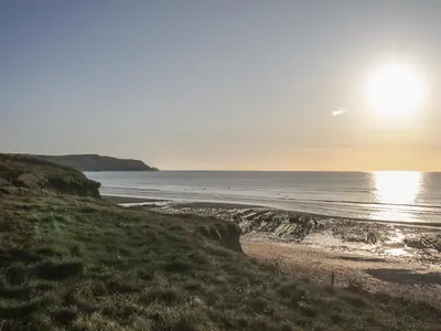 a beach with the sun rising over the ocean at Swallows Nest in Launceston