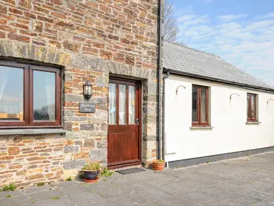 a brick building with a wooden door and windows at Swallows Nest in Launceston