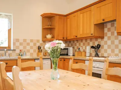 a vase of flowers sitting on a table in a kitchen at Barn Owl Cottage in Launceston