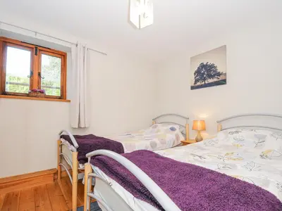 a bedroom with two twin beds and a window at Barn Owl Cottage in Launceston
