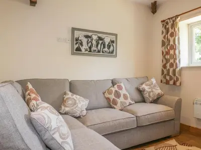 a living room with a gray couch with pillows at Garras Barn in Truro