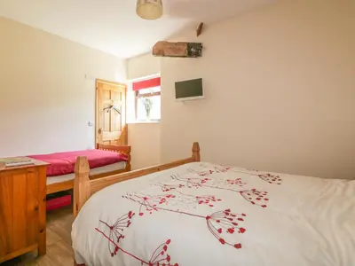 a bedroom with a bed and a table and a window at Garras Barn in Truro