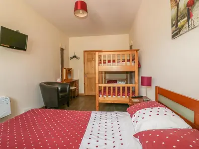 a bedroom with a bed and a chair and a television at Garras Barn in Truro