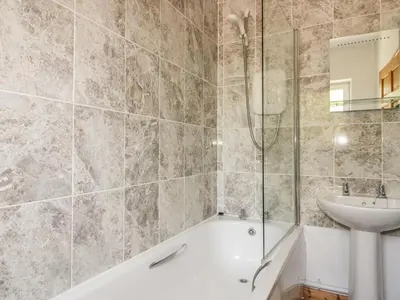 a bathroom with a bath tub and a sink at Garras Barn in Truro