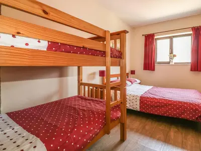 two bunk beds in a small room with red at Garras Barn in Truro