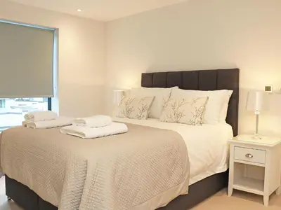 a bedroom with a large bed with two towels on it at Little Fistral in Newquay