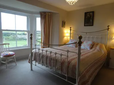 a bedroom with a bed and a window at Heatherdale in Tintagel