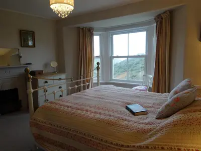 a bedroom with a bed with a book on it at Heatherdale in Tintagel
