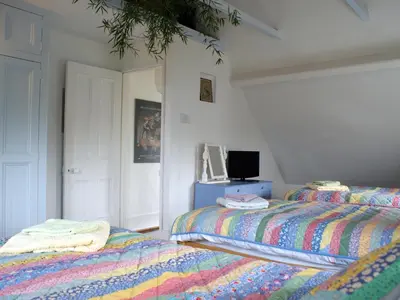 a bedroom with two beds and a tv on a table at Heatherdale in Tintagel