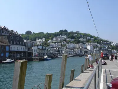 a man standing on a dock next to a body of water at Samuels Cottage in Lanreath