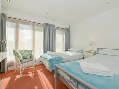 a bedroom with two beds and a chair and a window at Hideaway Barn in Charlestown