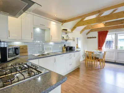 a kitchen with white cabinets and a stove top oven at Hideaway Barn in Charlestown