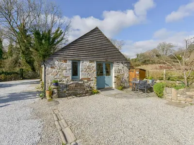 a small stone cottage with a blue door at Hideaway Barn in Charlestown