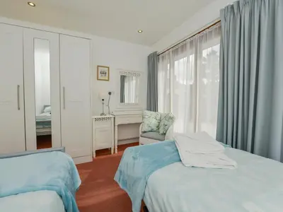 a bedroom with two beds and a desk and a window at Hideaway Barn in Charlestown