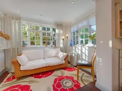 a living room with a white couch and windows at Orchard Lodge in Boscastle