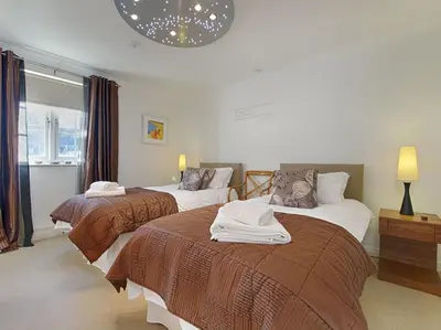 a hotel room with two beds and a window at Orchard Lodge in Boscastle