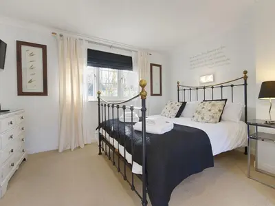 a bedroom with two beds and a dresser and a window at Orchard Lodge in Boscastle