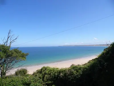a beach with people swimming in the water at Seaside Bungalow in St Ives
