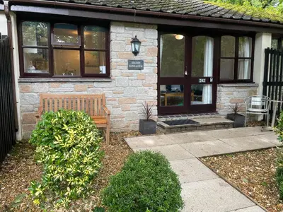 a brick house with a bench in front of it at Seaside Bungalow in St Ives