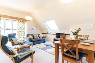 a dining room and living room with a table and chairs at 3 The Old School House in St. Agnes