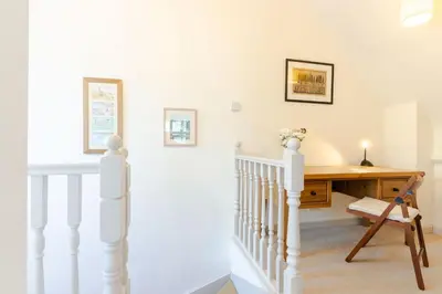 a staircase with a desk in a house at 3 The Old School House in St. Agnes