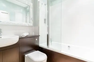 a bathroom with a toilet and a sink and a mirror at 3 The Old School House in St. Agnes