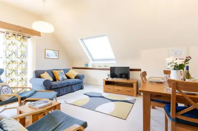 a living room with a blue couch and a table at 3 The Old School House in St. Agnes