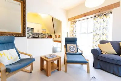 a living room with two chairs and a table at 3 The Old School House in St. Agnes