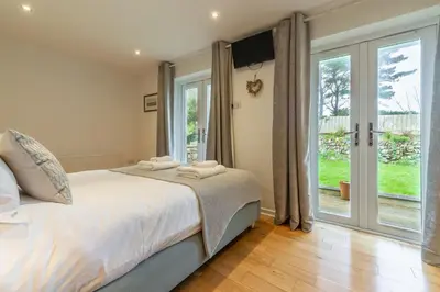 a bedroom with a bed and sliding glass doors at Amaroo in St. Agnes