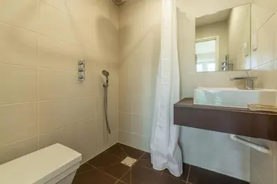 a bathroom with a shower and a toilet and a sink at Amaroo in St. Agnes