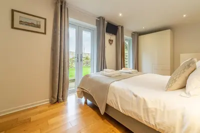 a bedroom with a bed and a large window at Amaroo in St. Agnes