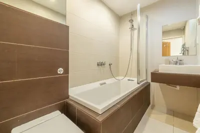 a bathroom with a bath tub and a sink at Amaroo in St. Agnes