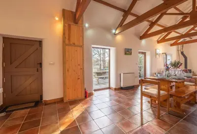 a living room with a wooden door and a table at Church Close Cottage in Gwennap