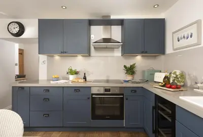 a kitchen with blue cabinets and a sink at Cob Cottage in St. Agnes