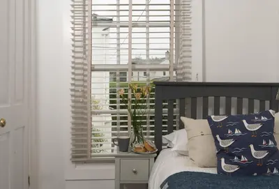 a bedroom with a bed in front of a window at Cob Cottage in St. Agnes