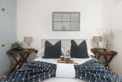 a bedroom with a bed with a tray of fruit on it at Cob Cottage in St. Agnes